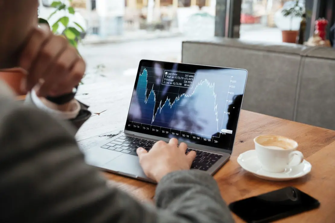 Cropped image of business man sitting by table in cafe
